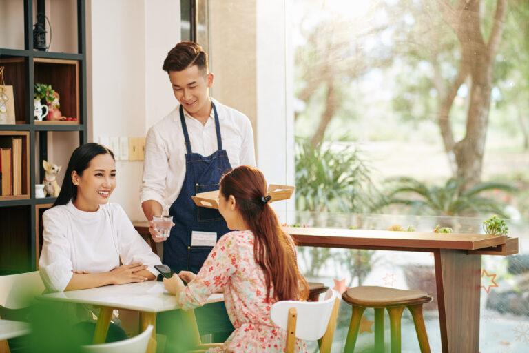 Waiter serving water to customers